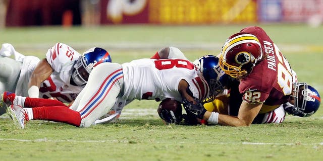 Sep 25, 2014; Landover, MD, USA; New York Giants cornerback Trumaine McBride (38) recovers a fumble by Washington Redskins tight end Logan Paulsen (82) in the second quarter at FedEx Field. Mandatory Credit: Geoff Burke-USA TODAY Sports