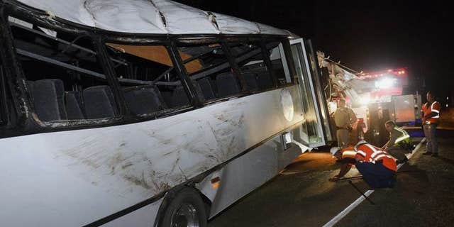In this Sept, 24, 2016 photo, rescuers work the scene of an accident after a tour bus carrying students from China hit a tree near Yosemite National Park outside the Sierra Nevada town of Oakhurst, Calif.