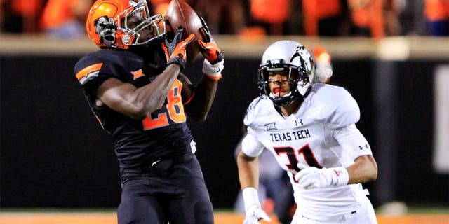 Sep 25, 2014; Stillwater, OK, USA; Oklahoma State Cowboys wide receiver James Washington (28) makes a catch in front of Texas Tech Red Raiders defensive back Justis Nelson (31) during the third quarter of a game at Boone Pickens Stadium. Oklahoma State won 45-35. Mandatory Credit: Alonzo Adams-USA TODAY Sports