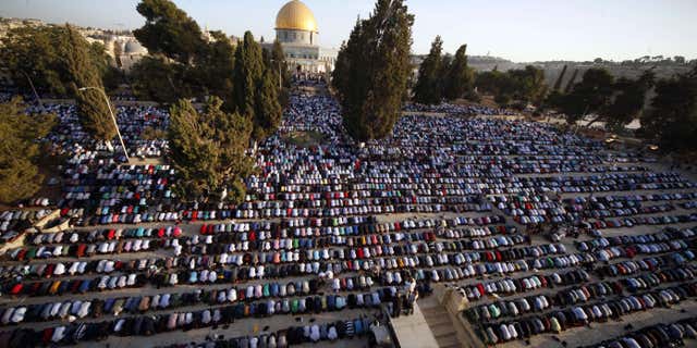 FILE - In this Thursday, Sept. 24, 2015. file photo, Palestinians pray during the Muslim holiday of Eid al-Adha, near the Dome of the Rock Mosque.