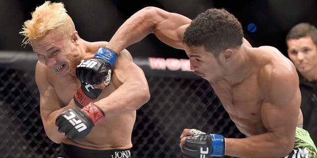 LAS VEGAS, NV - SEPTEMBER 27: Kevin Lee punches Jon Tuck in their lightweight fight during the UFC 178 event inside the MGM Grand Garden Arena on September 27, 2014 in Las Vegas, Nevada. (Photo by Jeff Bottari/Zuffa LLC/Zuffa LLC via Getty Images)