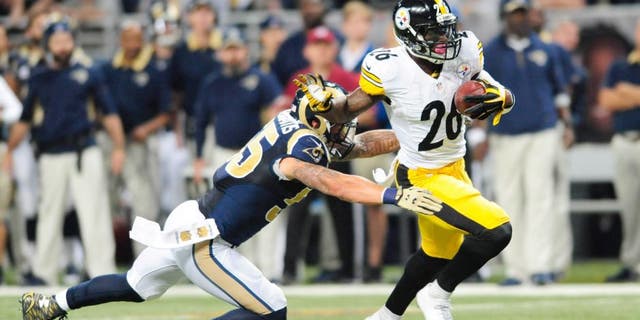 Sep 27, 2015; St. Louis, MO, USA; Pittsburgh Steelers running back Le'Veon Bell (26) carries the ball away from St. Louis Rams middle linebacker James Laurinaitis (55) during the first half at The Edward Jones Dome. Mandatory Credit: Joshua Lindsey-USA TODAY Sports