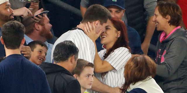 Sept. 27, 2016: Andrew Fox and Heather Terwilliger embrace after getting engaged during a baseball game between the New York Yankees and the Boston Red Sox in New York.