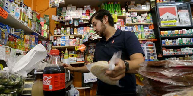 Sept. 21, 2016: Alex Del Rio works behind the counter at his family's market El Ahorro in San Francisco
