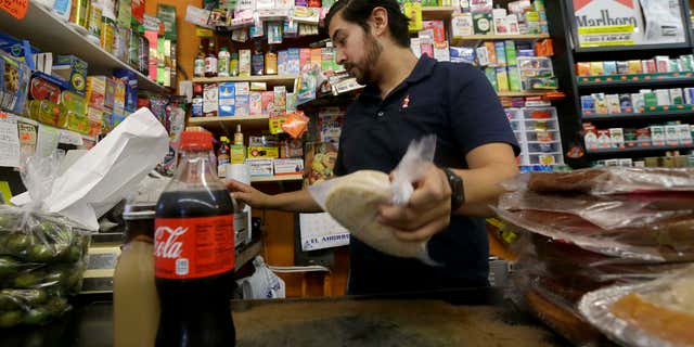 Sept. 21, 2016: Alex Del Rio works behind the counter at his family's market El Ahorro in San Francisco