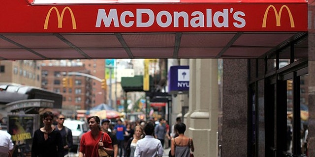 Sept. 9: People walk by a McDonalds in New York City. McDonald's Corp. is one of the 222 companies that have notified federal regulators it's health insurance plan for nearly 30,000 hourly restaurant workers isn't compatible with a new requirement of the U.S. health overhaul.