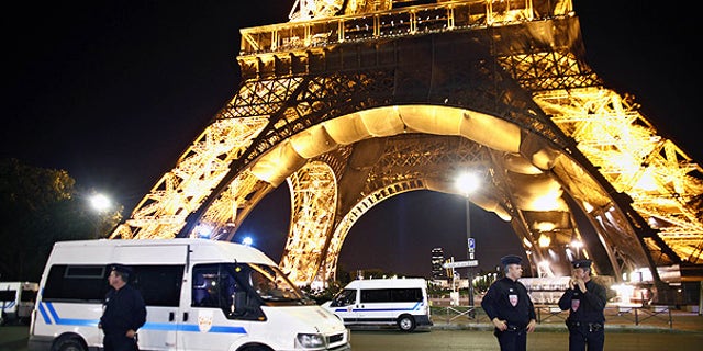 Police officers stand in front of the Eiffel Tower, in Paris, after an anonymous caller phoned in a bomb threat.