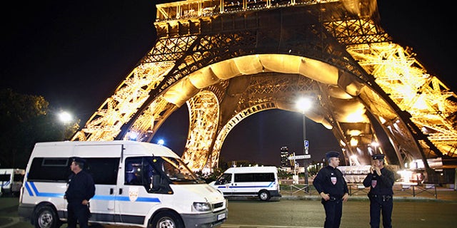 Police officers stand in front of the Eiffel Tower, in Paris, after an anonymous caller phoned in a bomb threat.