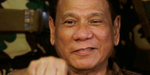 FILE - In this Aug. 25, 2016, file photo, Philippine President Rodrigo Duterte gestures with a fist bump during his visit to the Philippine Army's Camp Mateo Capinpin at Tanay township, Rizal province east of Manila, Philippines.