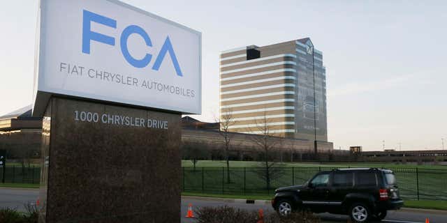 FILE - In this Tuesday, May 6, 2014, file photo, a vehicle moves past a sign outside Fiat Chrysler Automobiles world headquarters in Auburn Hills, Mich.