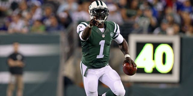 Aug 22, 2014; East Rutherford, NJ, USA; New York Jets quarterback Michael Vick (1) scrambles against the New York Giants during the second half at MetLife Stadium. The Giants defeated the Jets 35-24. Mandatory Credit: Adam Hunger-USA TODAY Sports