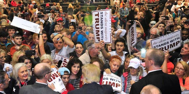 FILE - In this Nov. 21, 2015, file photo, the crowd surges to greet Republican presidential candidate Donald Trump after he spoke in Birmingham, Ala. In less than a month, voters will begin casting their ballots in what could turn out to be a bitter, months-long fight for the Republican nomination. (AP Photo/Eric Schultz, File)