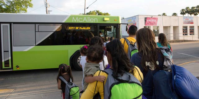 Immigrant families board a bus headed to the downtown bus station in McAllen, Texas on April 30, 2015.