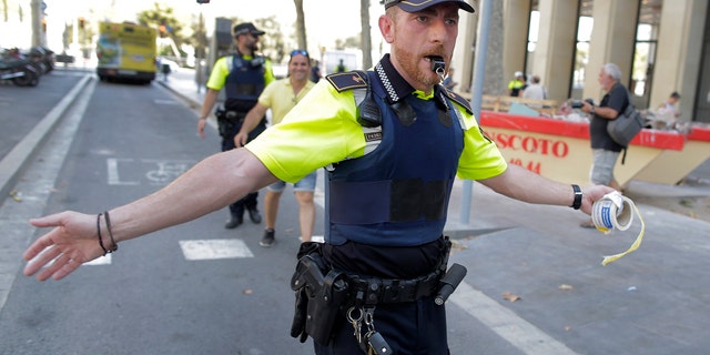 A police officer cordon off a street in Barcelona, Spain, Thursday, Aug. 17, 2017. Police in the northern Spanish city of Barcelona say a white van has jumped the sidewalk in the city's historic Las Ramblas district, injuring several people. (AP Photo/Manu Fernandez)