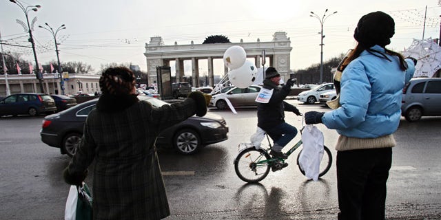 Feb. 19: People standing on a sidewalk wave in support to the participants of the motorist's rally in Moscow.
