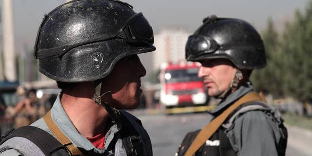 Afghan police soldiers inspect the site of a suicide attack in Kabul, Afghanistan, Monday, June 20, 2016. At least a dozen Nepalese security guards of a foreign logistic company were killed Monday when a Taliban suicide bomber targeted their minibus in the Afghan capital, interior ministry and an Afghan security official said. (AP Photo/Rahmat Gul)