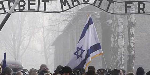Jan. 27: Visitors under the infamous Arbeit Macht Frei 'Work Sets You Free' sign over the main gate of Auschwitz.
