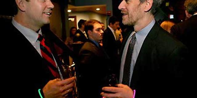 Feb. 4: Phil Berent of New York, right, with a pink bracelet indicating he is looking for work, speaks with recruiter Kevin Johnson.