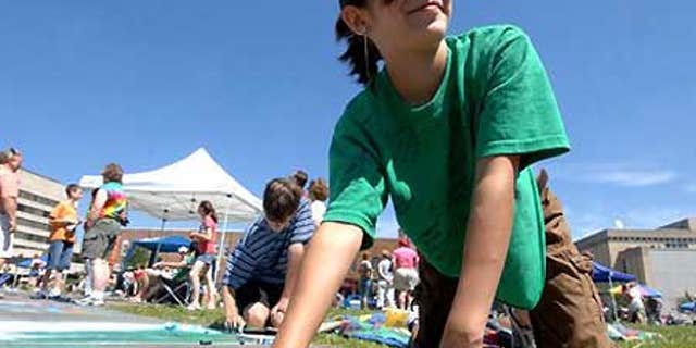 Madeline Kara Neumann works on chalk art during downtown Wausau's annual Chalk Fest.