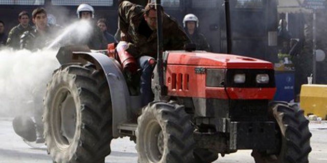 Feb. 3: A farmer riding a tractor uses a fire extinguisher against riot police, as a police officer responds with pepper spray, near Athens, Tuesday.