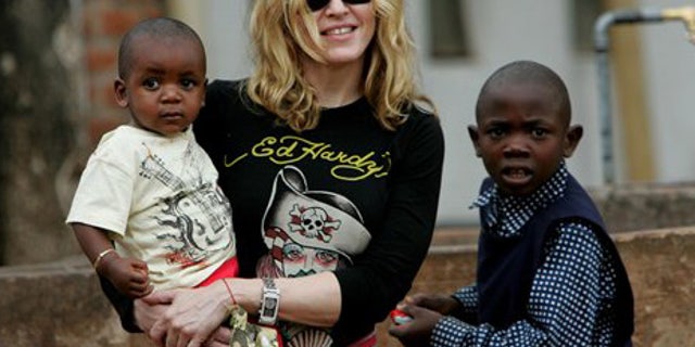 ** FILE **** FILE ** Madonna holds David Banda in her arms, in this April 19, 2007, file photo at Consol Homes, a day care center that she is funding in the village of Masekese, Malawi. Officials say Madonna is to travel to Malawi to try to adopt a second child from the impoverished African country. An official at the Malawi welfare department said Thursday, March 26, 2009 that the pop star has filed adoption papers. (AP Photo/Karel Prinsloo, File)