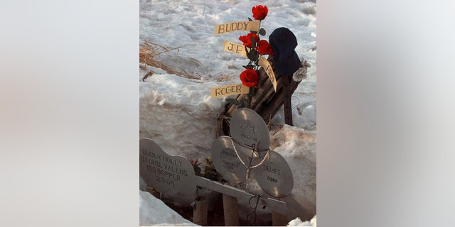 **FILE** Flowers adourn a memorial Feb. 6, 1999, at the spot where the plane carrying Buddy Holly, Ritchie Valens, J.P. "The Big Bopper" Richardson and their pilot Roger Peterson crashed, killing all aboard Feb. 3, 1959, near Clear Lake, Iowa. The son of "The Big Bopper," Jay Richardson, has hired a forensic anthropologist to answer questions about how his father died in the 1959 plane crash along with rock 'n' rollers Holly and Valens. (AP Photo/Rodney White, File)