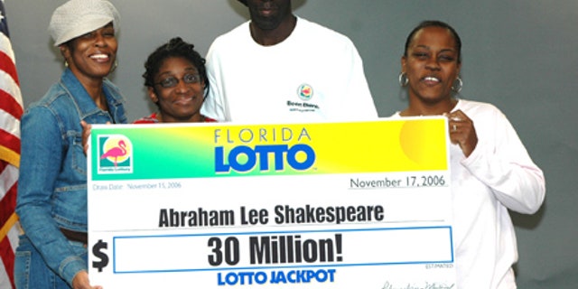 Abraham Shakespeare, center, displays an oversized check after winning the lottery in 2006. The last time anyone saw Shakespeare was in April.