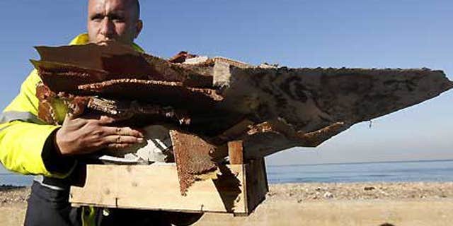 Jan. 27: Workers gather debris washed ashore at the beach in Khalde, south of Beirut.
