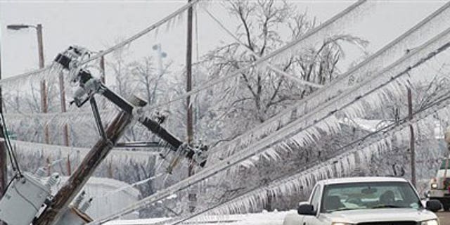 Jan. 31: A vehicle prepares to pass the top of a power pole that fell onto the sidewalk along 3rd Street in Paducah, Ky.