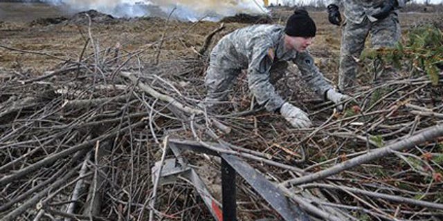 Feb. 2: Kentucky National guard members William Swartwood, left, and Jerry Bailey help unload branches from the back of a truck.