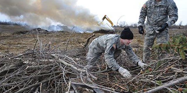 Feb. 2: Kentucky National guard members William Swartwood, left, and Jerry Bailey help unload branches from the back of a truck.