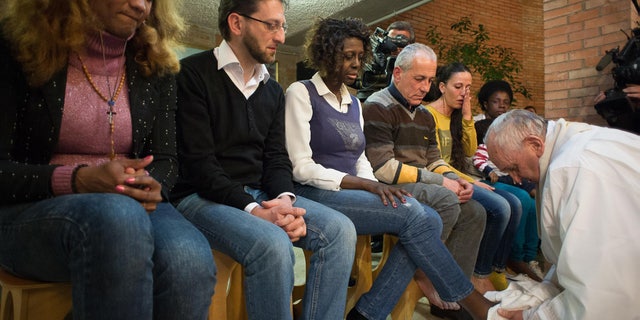 Pope Francis washes the foot of a woman at Rebibbia prison in Rome, Thursday, April 2, 2015.