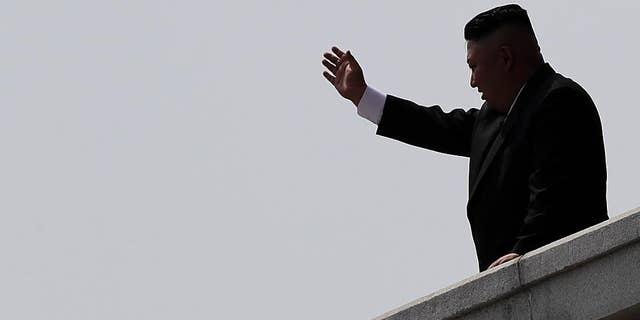 North Korean leader Kim Jong Un is seen in silhouette as he waves during a military parade on Saturday, April 15, 2017, in Pyongyang, North Korea to celebrate the 105th birth anniversary of Kim Il Sung, the country's late founder and grandfather of current ruler Kim Jong Un. (AP Photo/Wong Maye-E)