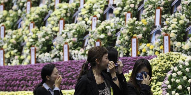People weep as they pay tribute to the victims of the sunken ferry Sewol at a group memorial altar in Ansan, south of Seoul, South Korea, Tuesday, April 29, 2014. South Korean President Park Geun-hye apologized Tuesday for the government's inept initial response to a deadly ferry sinking as divers fought strong currents in their search for nearly 100 passengers still missing nearly two weeks after the accident.(AP Photo/Ahn Young-joon)