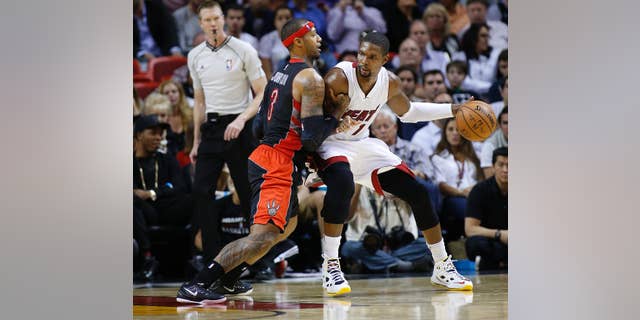 Toronto Raptors’ James Johnson (3) defends against Miami Heat's Chris Bosh (1) as he attempts to drive to the basket during the second half of an NBA basketball game in Miami, Sunday, Nov 2, 2014. The Heat defeated the Raptors 107-102. (AP Photo/Joel Auerbach)