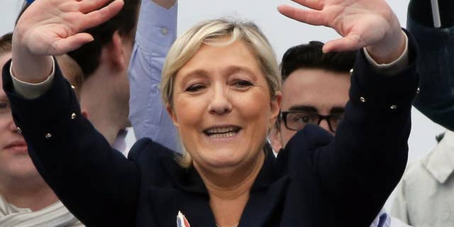 France’s far-right National Front president Marine Le Pen waves to supporters after her speech at Opera Plaza during the annual May Day march, in Paris, France, Friday, May 1, 2015. France’s far-right National Front is holding its annual May Day march, but for the first time the party’s founder Jean-Marie Le Penis not taking a seat at the tribune. (AP Photo/Francois Mori)