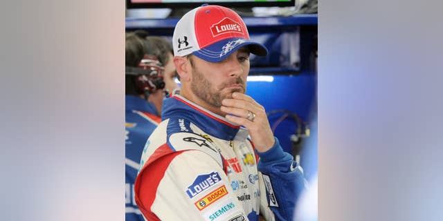 Driver Jimmie Johnson waits by his car before practice for Saturday's NASCAR Sprint Cup series auto race at Charlotte Motor Speedway in Concord, N.C., Friday, May 16, 2014. (AP Photo/Mike McCarn)
