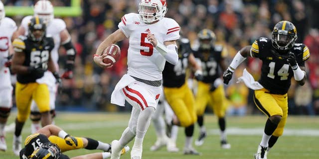 Wisconsin quarterback Tanner McEvoy (5) runs from Iowa defensive back John Lowdermilk (37) and defensive back Desmond King (14) during a 45-yard touchdown run in the first half of an NCAA college football game, Saturday, Nov. 22, 2014, in Iowa City, Iowa. (AP Photo/Charlie Neibergall)