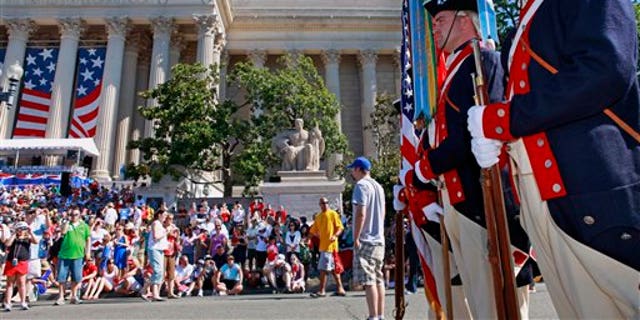 Soldiers with the 3rd U.S. Infantry Regiment Old Guard Continental Color Guard line up near the National Archives building, left, in Washington before the start of the Fourth of July, Independence Day, festivities Sunday, July 4, 2010. (AP Photo/Jacquelyn Martin)