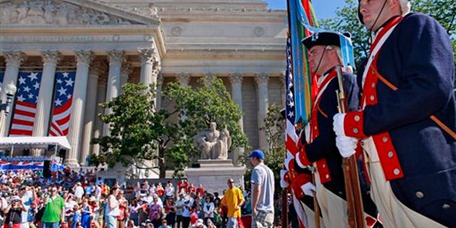 Soldiers with the 3rd U.S. Infantry Regiment Old Guard Continental Color Guard line up near the National Archives building, left, in Washington before the start of the Fourth of July, Independence Day, festivities Sunday, July 4, 2010. (AP Photo/Jacquelyn Martin)