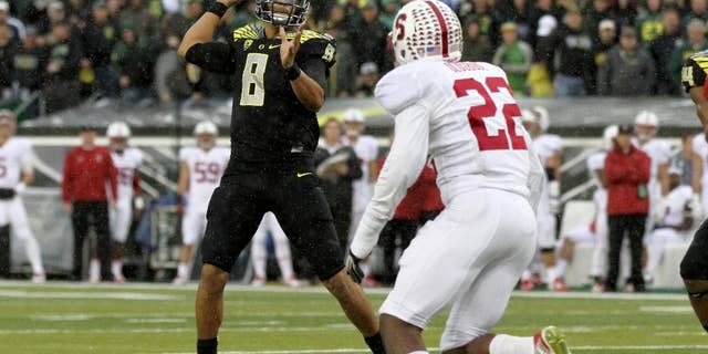 Oregon quarterback Marcus Mariota (8) looks to throw towards the end zone during the first quarter against Stanford in an NCAA college football game in Eugene, Ore., Saturday, Nov. 1, 2014. (AP Photo/Ryan Kang)