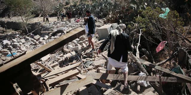 Men walk amid the rubble of a house destroyed by a Saudi-led airstrike on the outskirts of Sanaa, Yemen, Thursday, Feb. 2, 2017. (AP Photo/Hani Mohammed)