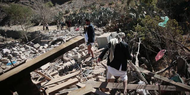 Men walk amid the rubble of a house destroyed by a Saudi-led airstrike on the outskirts of Sanaa, Yemen, Thursday, Feb. 2, 2017. (AP Photo/Hani Mohammed)
