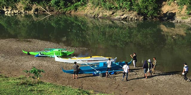 FILE - This undated photo provided by the Armed Forces of the Philippines on April 12, 2017, shows people stand by boats which the military said were used by Abu Sayyaf militants to enter the Ibananga River in Bohol province, central Philippines, as government troopers continue clearing operations. Philippine officials said Saturday, April 15, 2017, that an investigation shows that a foiled attack on a resort island this week was a kidnapping and bombing mission by at least three nascent groups affiliated with the Islamic State group. (3rd ID, Armed Forces of the Philippines via AP, File)
