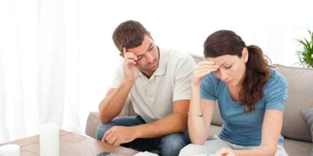 0d623a8e-Worried couple doing their accounts in the living room