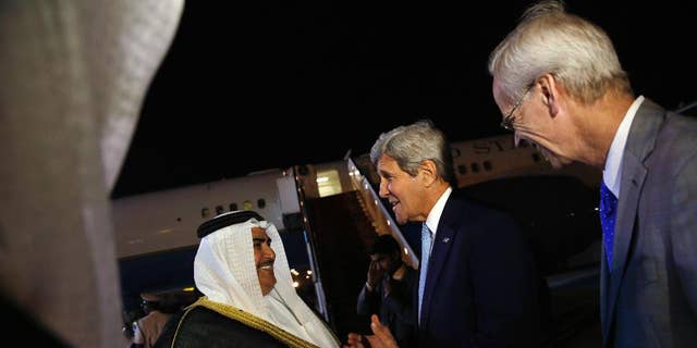 FILE - Bahrain Foreign Minister Khalid bin Ahmed Al Khalifa, left, and U.S. Ambassador to Bahrain William Roebuck, right, greet U.S. Secretary of State John Kerry, center, as he arrives at Bahrain International Airport in Manama, Bahrain, April 6, 2016.