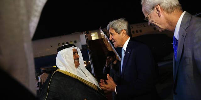 FILE - Bahrain Foreign Minister Khalid bin Ahmed Al Khalifa, left, and U.S. Ambassador to Bahrain William Roebuck, right, greet U.S. Secretary of State John Kerry, center, as he arrives at Bahrain International Airport in Manama, Bahrain, April 6, 2016.