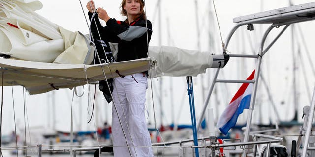 In this file photo dated Wednesday, Aug. 4, 2010 Laura Dekker hoists a flag of The Sea Shepherd Conservation Society on her boat in the harbor of Den Osse, southwest Netherlands. The 14-year-old Dutch girl will try to become the youngest person to sail solo around the world when she sets off from Portugal on Saturday Aug. 21, 2010. Laura Dekker's ambition of completing the yearlong trip has fueled a global debate over the wisdom of allowing young sailors to take on the tremendous risks of sailing the high seas alone.