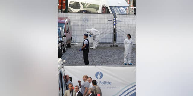 Forensic experts examine the site of a shooting at the Jewish museum in Brussels, Saturday, May 24, 2014. Belgian officials say that at least three people have been killed in gunfire at the Jewish Museum in Brussels. Belgian Foreign Minister Didier Reynders, in a post on Twitter, said he was "shocked by the murders committed at the Jewish Museum" on Saturday afternoon. He said he had seen the bodies of the victims. At least three persons were killed in the incident, and a Brussels fire department spokesman said one person was wounded. (AP Photo/Yves Logghe)