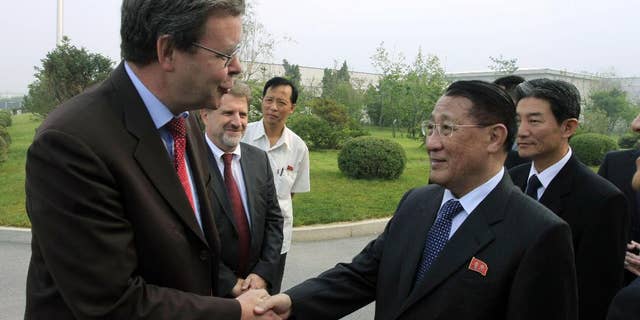 FILE - In this Sept. 6, 2014 file photo, North Korea's Kang Sok Ju, right, a member of the Political Bureau of the Central Committee of the Workers' Party of Korea (WPK) and secretary of the WPK, shakes hands with German Ambassador to North Korea Thomas Schaefer as he leaves Pyongyang Airport in Pyongyang, North Korea to visit Germany, Belgium, Switzerland, Italy and Mongolia. Kang, a top North Korean diplomat who negotiated a short-lived 1994 deal with the United States to freeze its nuclear programs in exchange for international aid, has died of cancer, the country's state media said Saturday, May 21, 2016. (AP Photo/Kim Kwang Hyon, File)